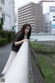 A woman leaning on a railing in the middle of a city.