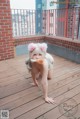 A woman in bunny ears is posing on a wooden deck.