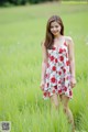 A woman standing in a field of tall grass.