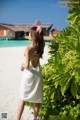 A woman in a white dress standing on a beach.