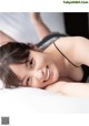 A woman laying on top of a bed smiling.