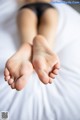 A close up of a person's feet on a bed.