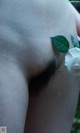 A close up of a person holding a white rose in their hand.