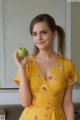 A woman in a yellow dress holding an apple.