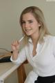 A woman sitting at a desk smoking a cigarette.